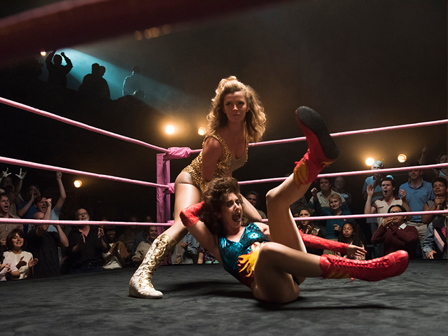 Betty Gilpin, standing, wrestles Alison Brie in "GLOW."