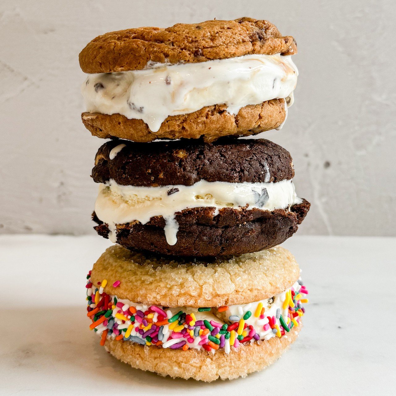 Très Belle Cakes
8921 Reading Road, Reading
Ice Cream Cookie Sandwich: A thick layer of ice cream sandwiched between two big homemade cookies. Availabile in your choice of one of three flavors: Toffee Chip Cookie with Toffee Caramel Ice Cream, Triple Chocolate Cookie with Chocolate Chip Ice Cream or the Signature Sparkle Sugar Cookie with Vanilla Bean Ice Cream and sprinkles.