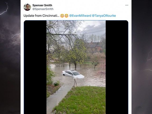A car floating on a flooded street, captured by X user @SpenserSm1th.