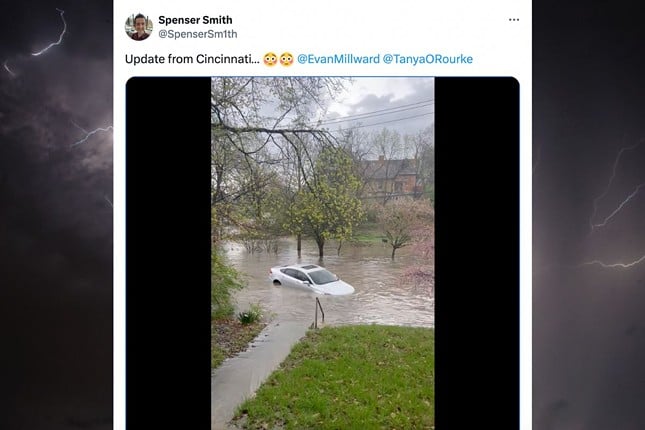 A car floating on a flooded street, captured by X user @SpenserSm1th.