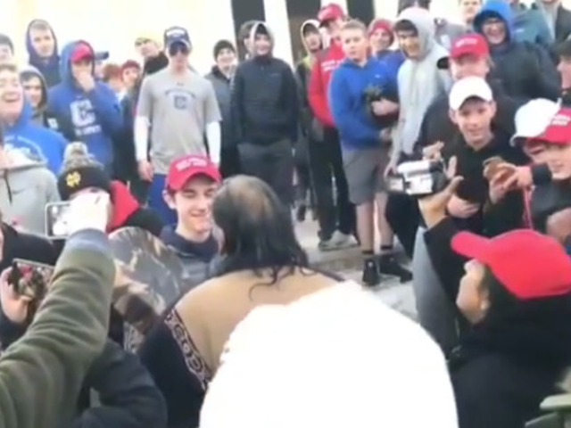 Indigenous activist Nathan Phillips in the middle of a crowd of students from Covington Catholic High School