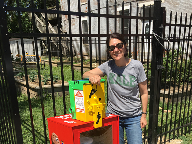 Lisa Andrews with one of her newspaper boxes/food pantries