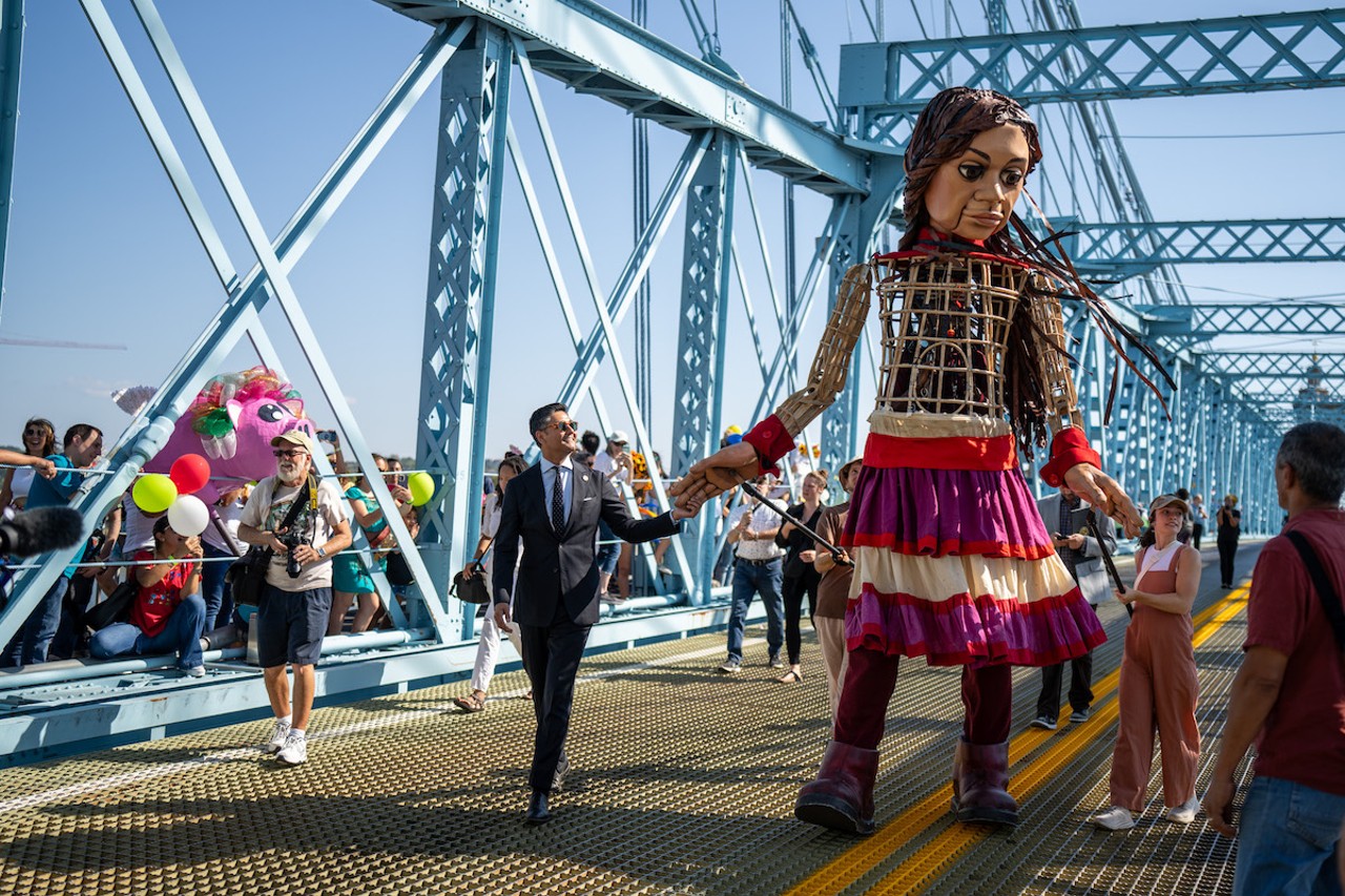 Cincinnati Mayor Aftab Pureval walks with Little Amal across the Roebling Bridge