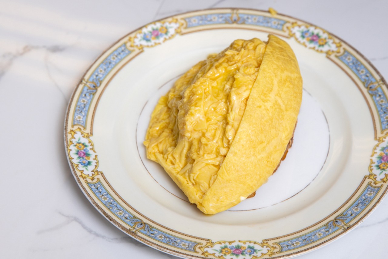 The performative flair comes in when Bentz delicately slices the top of his seamless omelet with a razor-sharp knife. The eggs unfurl like an umbrella over the rice and creamy scrambled eggs rain down from the center.