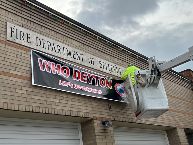 A crew adds a "Who Deyton" banner to the Bellevue-Dayton Firehouse.