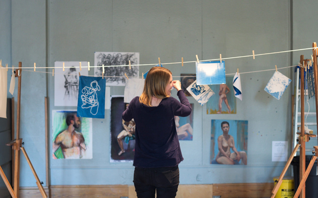 Kate Cunningham hangs light-developed cyanotype prints at Manifest Drawing Center.