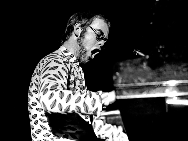 Elton John (circa 1972) at the exact moment he devises a scheme to one day cause a world leader to talk about his organ.