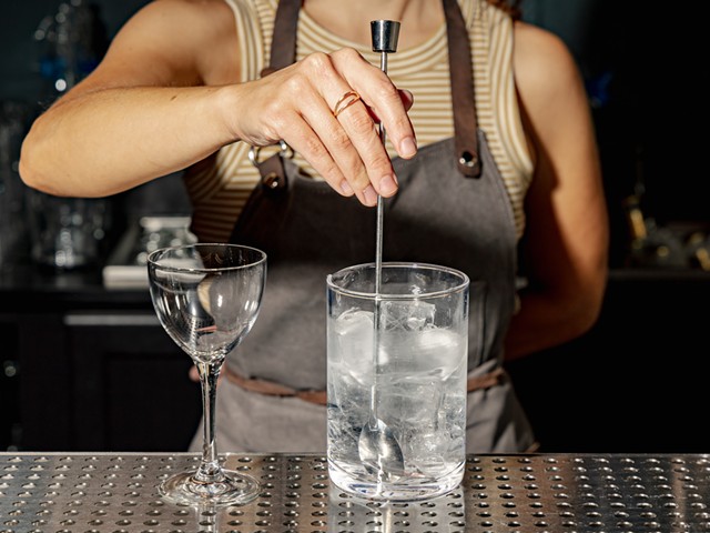 A bartender mixes a drink at Fifty Fifty Gin Club