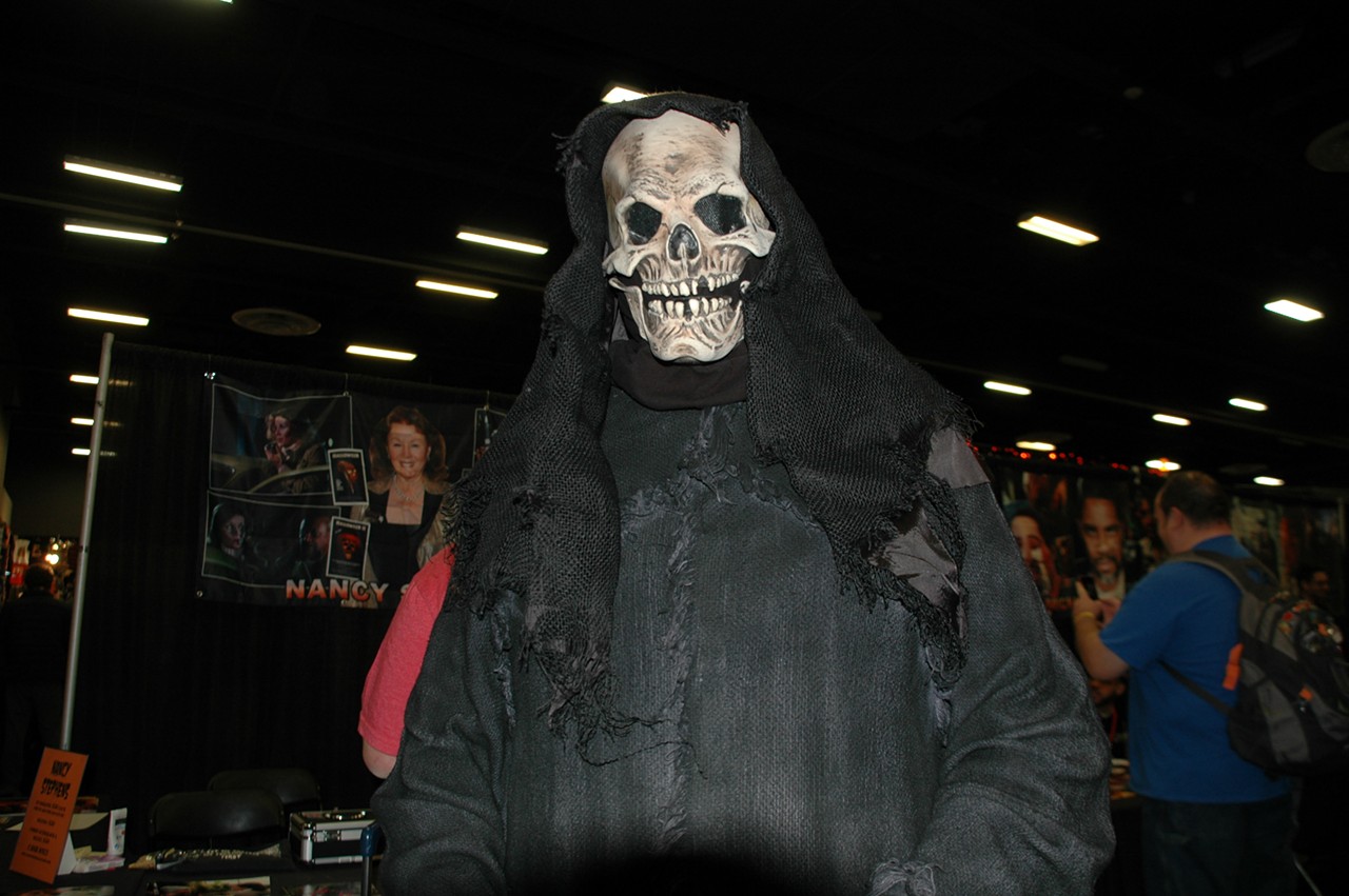The Grim Reaper walks among other costumed fans.