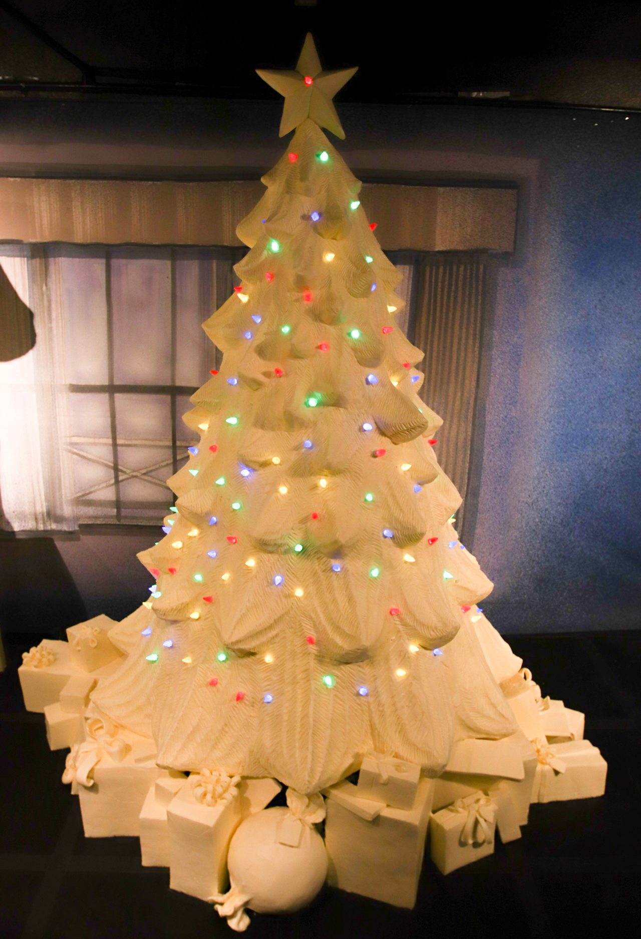 Sculptors incorporated twinkling lights into the Christmas tree butter sculpture.