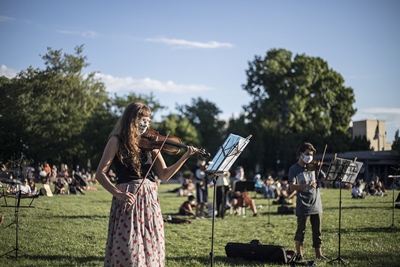 A musician plays during a vigil for Elijah McClain July 12 in Washington Park