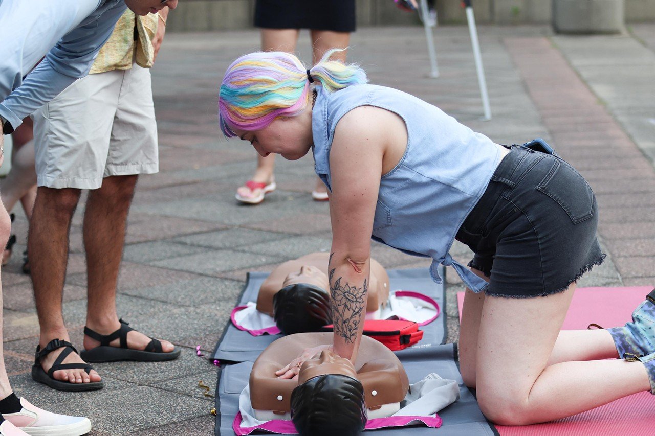 A woman teaches CPR at the Pride festival on Saturday, June 22, 2024.