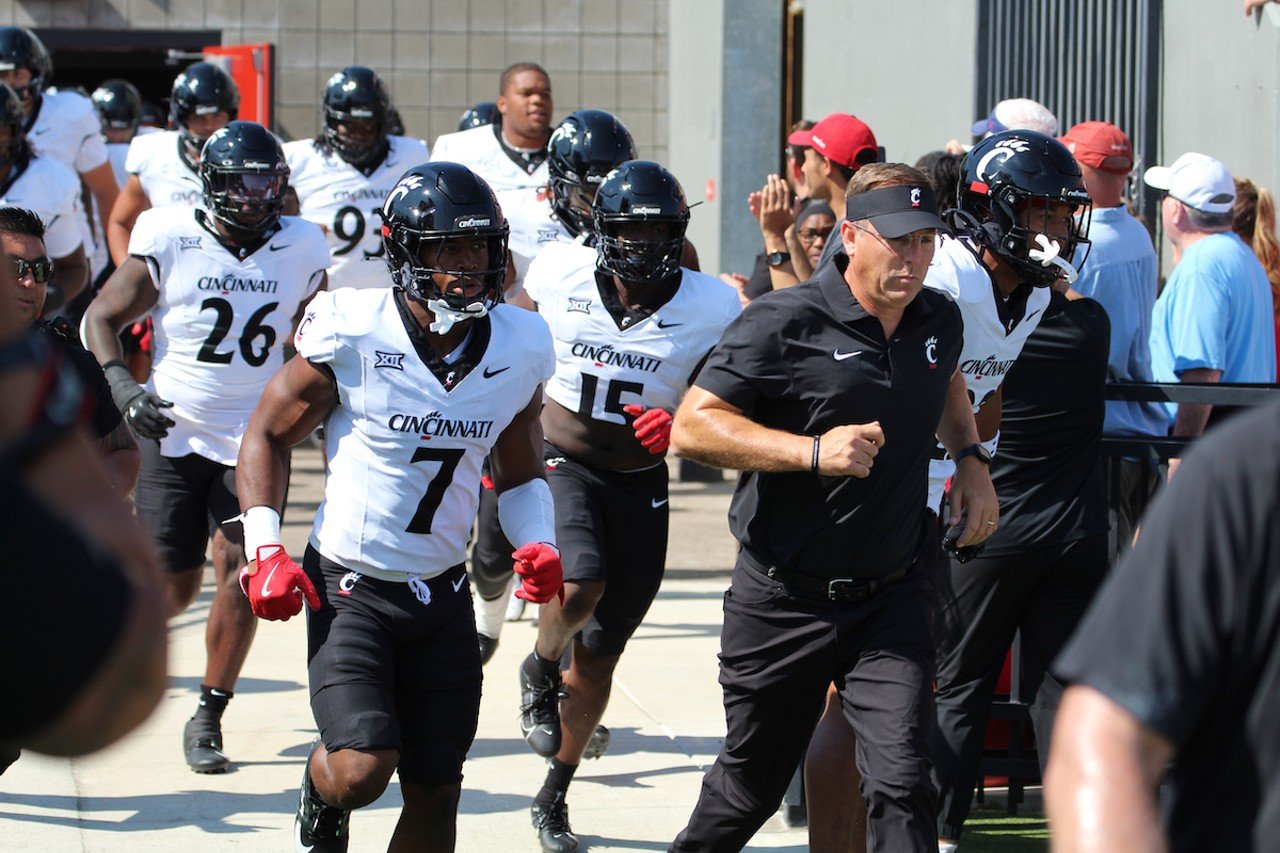 UC head football coach Scott Satterfield leads the team onto the field.