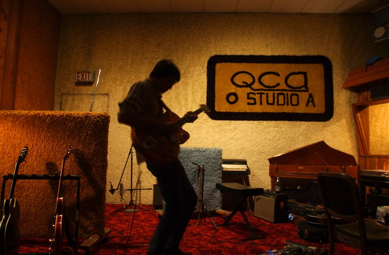 The original QCA logo on the wall in Ultrasuede Studio.