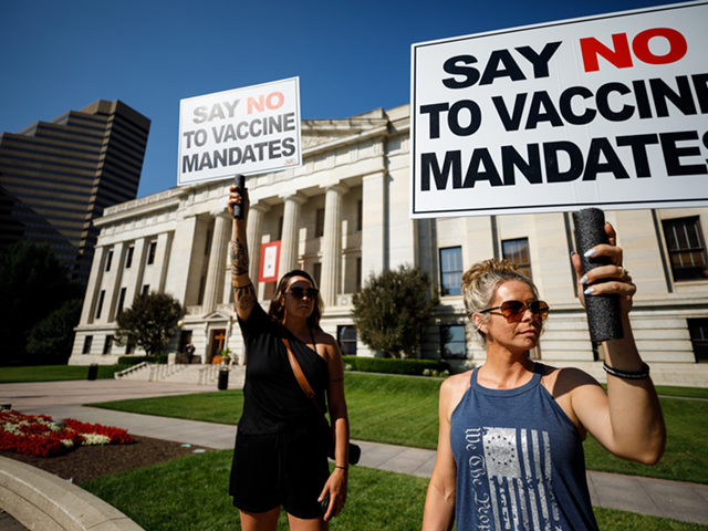 Two women protest vaccine mandates Aug. 24 outside a hearing at the Statehouse on legislation that would outlaw the practice from employers.