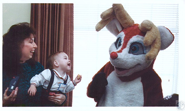 Burlington, 1991
    "Cassie Jo Hill (1), held by mother Connie, laughs at Rudolph the Red Nose Reindeer (Dan Maher)"