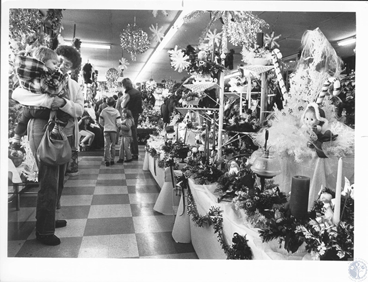 Covington, 1981
"Kathy Spauling and son David (2) looking at displays at Jackson Florist during open house"