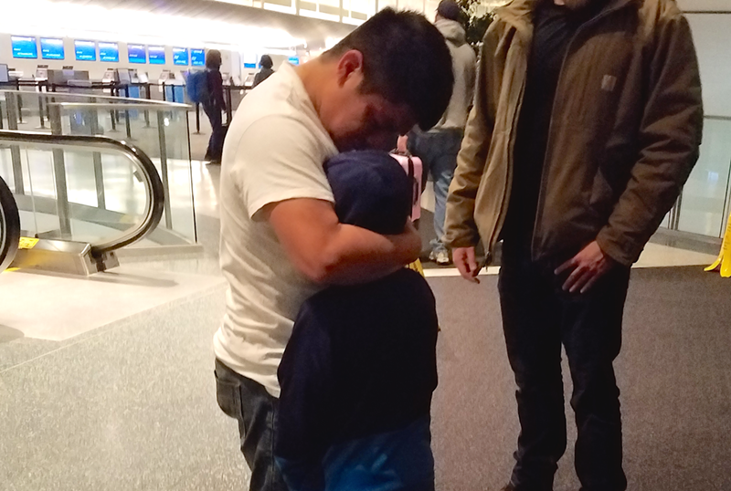 Benjamin Yat-Xicol embraces his son Danny before the two are escorted by ICE officers to an airplane bound for Guatemala. - Photo: Nick Swartsell
