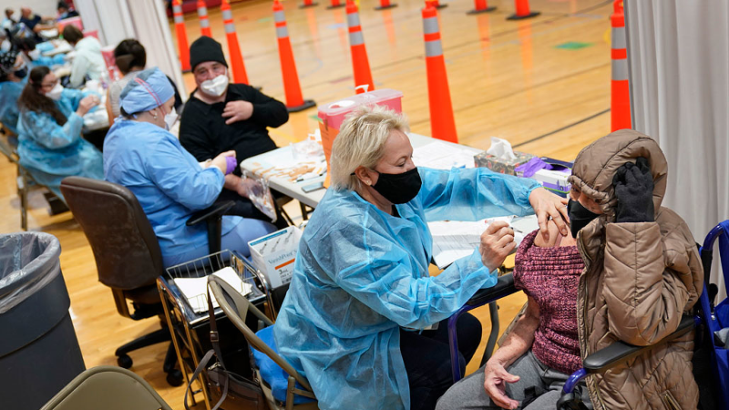 With COVID-19 vaccination ramping up across the United States, in clinics like this one in New Jersey, hopes are rising that the end of the pandemic is in sight. But masks and social distancing are still essential tools to control the pandemic. - Photo: Seth Wenig/AP
