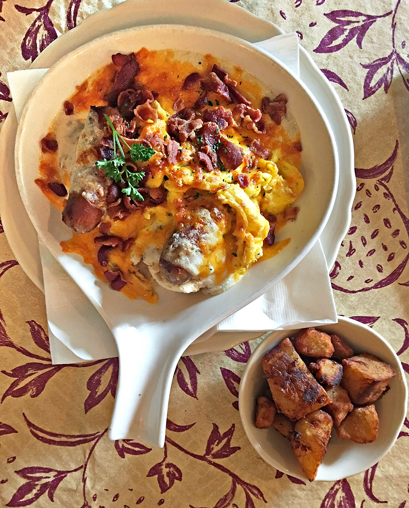 Greyhound Tavern's Breakfast Hotbrown — biscuits topped with sausage gravy and sausage links, scrambled eggs, cheese, bacon and tomato. - Photo: Zachary Petit