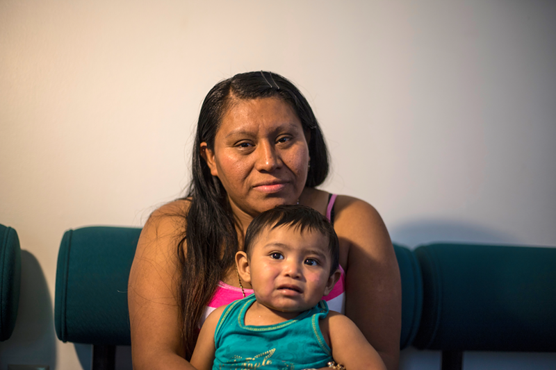 A woman and her young daughter sit at a help center for immigrants in suburban Cincinnati shortly before returning to Guatemala. - Photo: Nick Swartsell