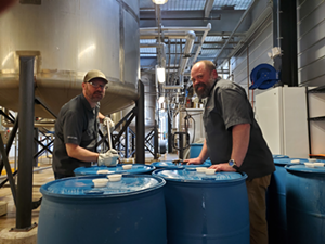 Head distiller Brian Sprance and distiller Bryon Martin filling the 55-gallon drums for distribution to first responders - Photo: Provided by New Riff