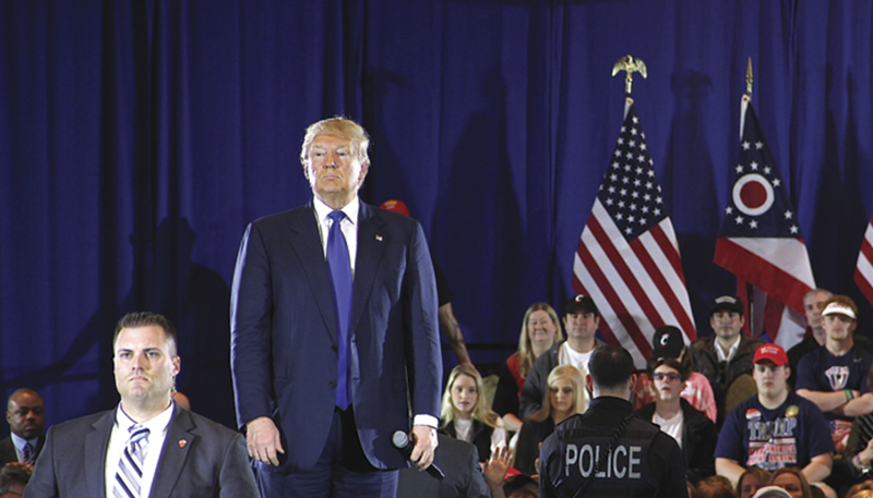 GOP presidential primary frontrunner Donald Trump stands with security personnel at a March 13 campaign rally in West Chester.