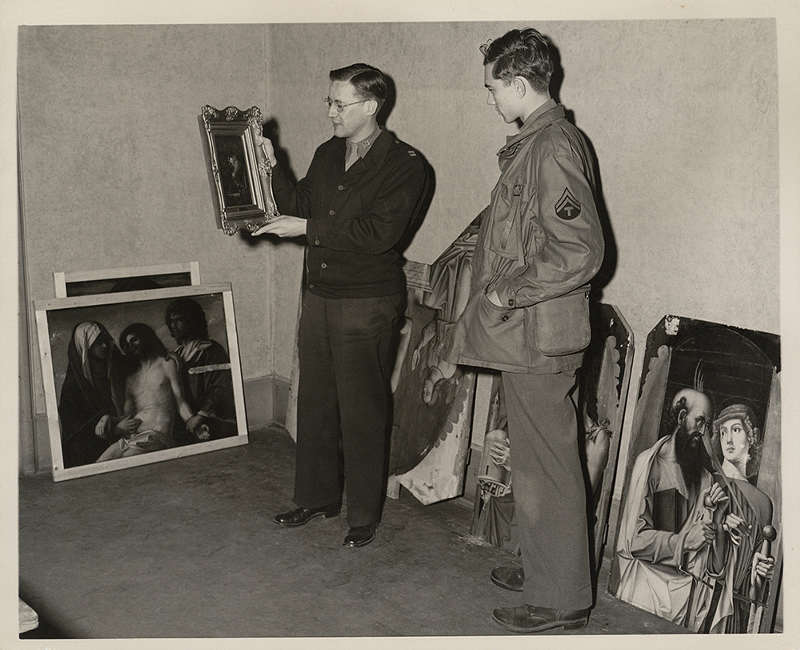 Walter Farmer holding a painting at Wiesbaden Central Collecting Point in Germany - Photo: Lindsay C. Kenneth Papers, Special Collections, Binghamton University Libraries, Binghamton University, State University of New York