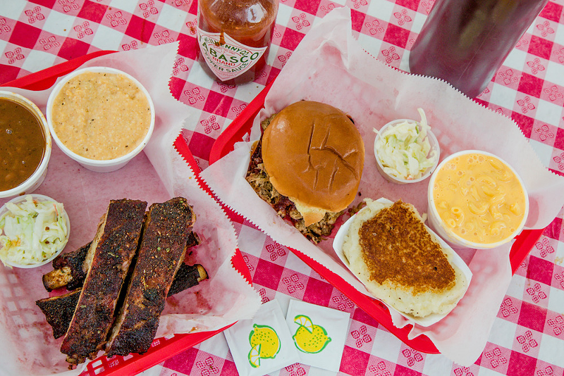 A spread of Eli's BBQ dishes, including a pulled-pork sandwich (in the middle) - Photo: Hailey Bollinger