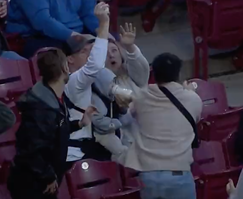 Jacob Kingsley catches a foul ball while feeding his infant son during a Cincinnati Reds game at Great American Ball Park on April 26, 2022. - Photo: twitter.com/ballysportscin