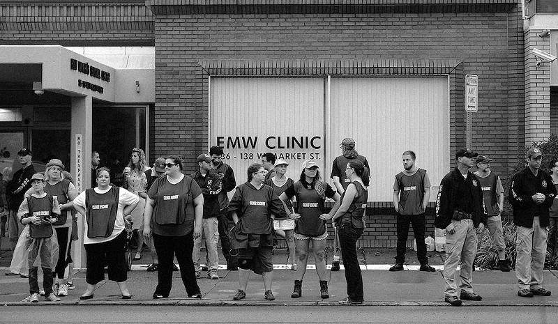 Clinic escorts stand outside of EMW Women’s Surgical Center in Louisville in 2017. - Photo: Daniel Hosterman