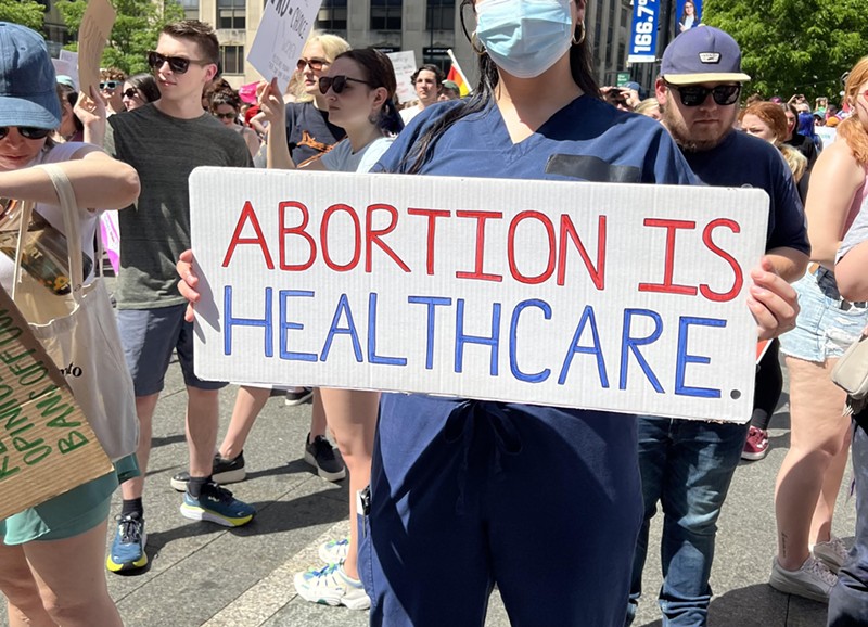 A nurse holds a sign in support of abortion access at a Planned Parenthood rally in Downtown Cincinnati on May 15, 2022. - Photo: Madeline Fening