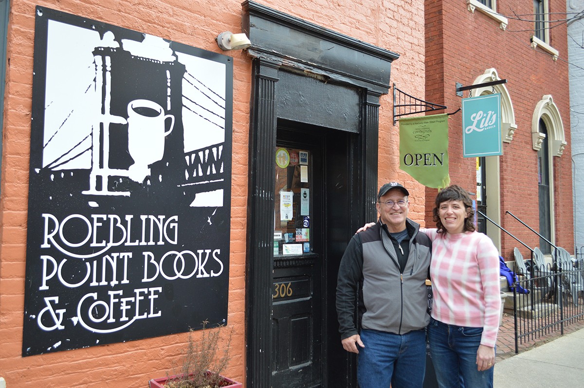 Richard Hunt, owner of Roebling Point Books & Coffee, and Julia Keister, owner of Lil's Bagels, pose in front of Roebling Point Books & Coffee in Covington.